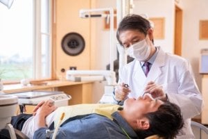 Dentist performing a procedure on a patient lying in a dental chair